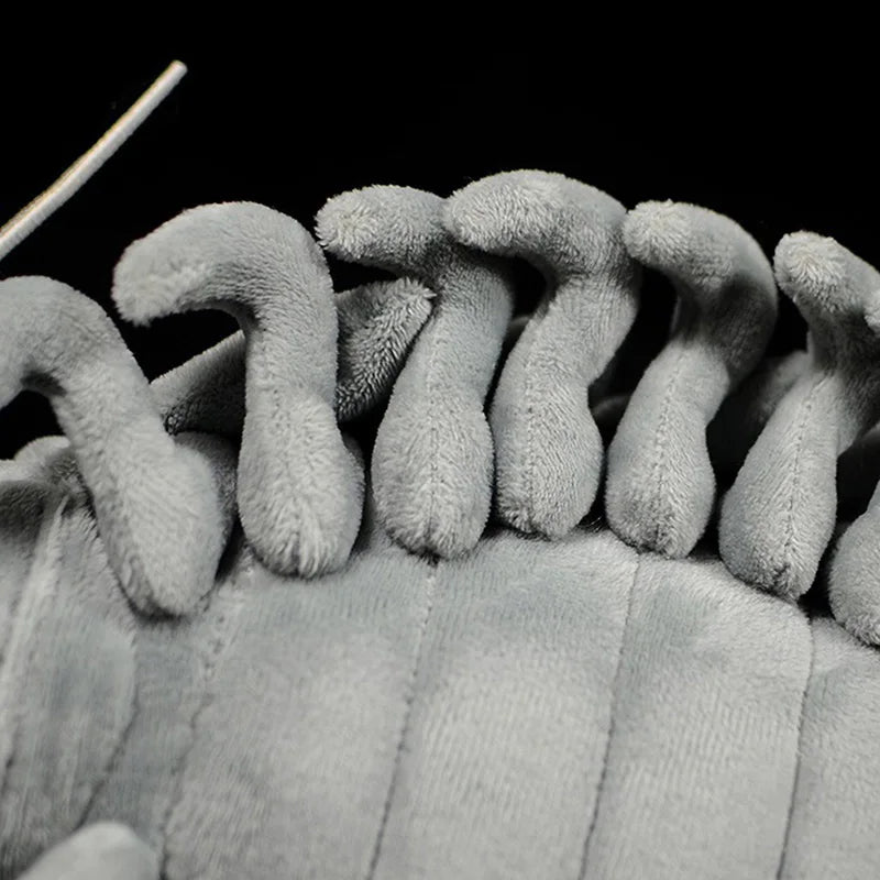 Cute isopod plush being held in hands to show scale