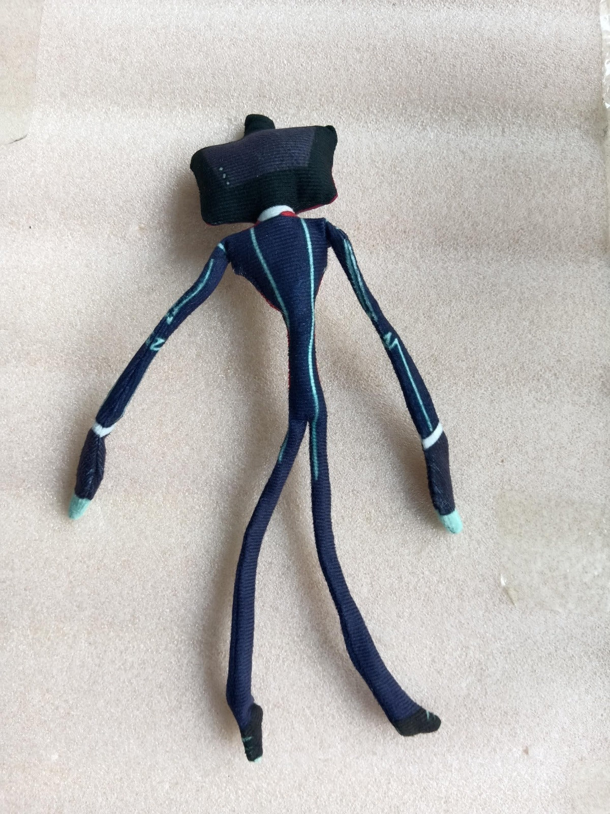 Hazbin_Hotel_Vox_stuffed_doll_showcasing_a_dark_blue_suit_with_white_trim_cyan_hands_and_a_jagged_glowing_grin_on_a_television_screen_head.supplier_update