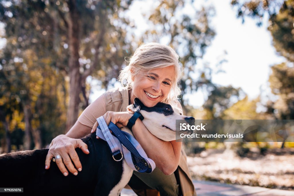 woman smiling with dog in sunny park, celebrating inclusive motherhood and dog mum bond 2026