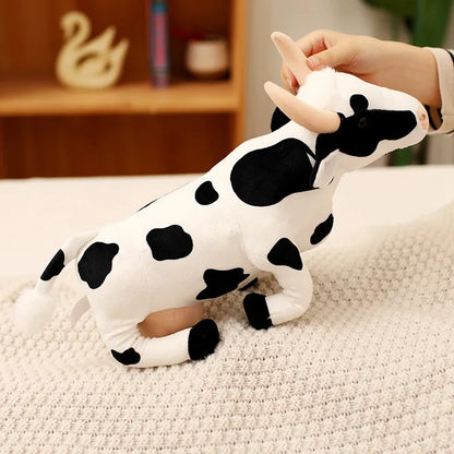 38cm cow plush size comparison next to everyday objects on a wooden table