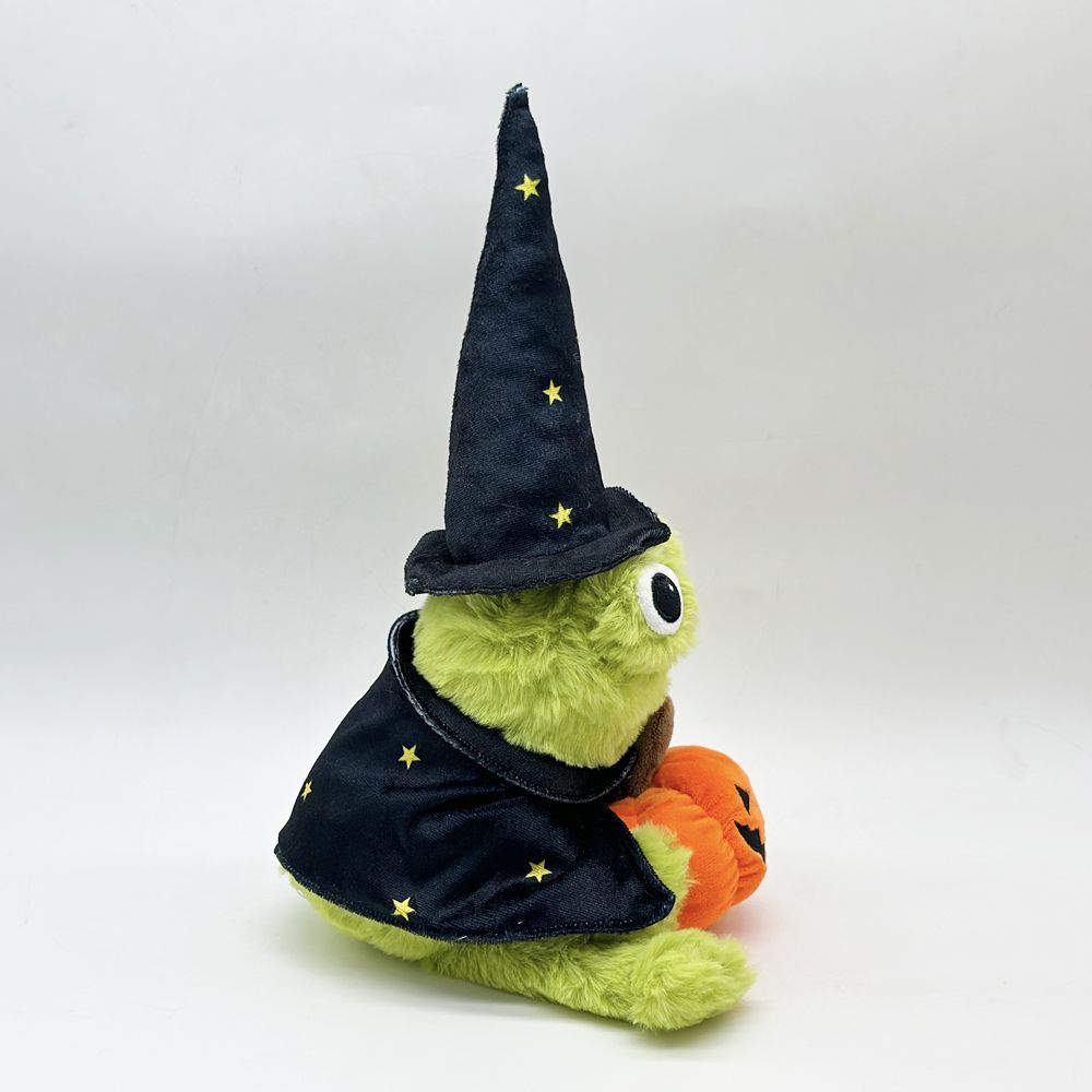 7. Spooky cute frog plush holding orange pumpkin close-up hand detail