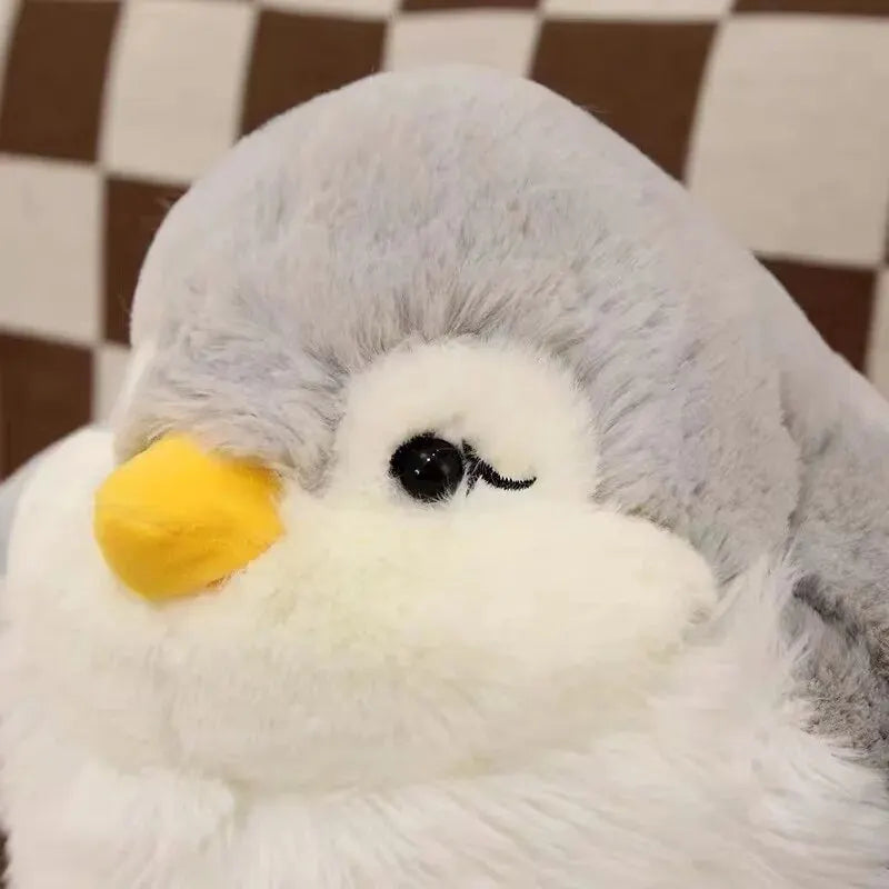 A soft penguin toy resting comfortably on a child's bed pillow.A soft penguin toy resting comfortably on a child's bed pillow.A soft penguin toy resting comfortably on a child's bed pillow.