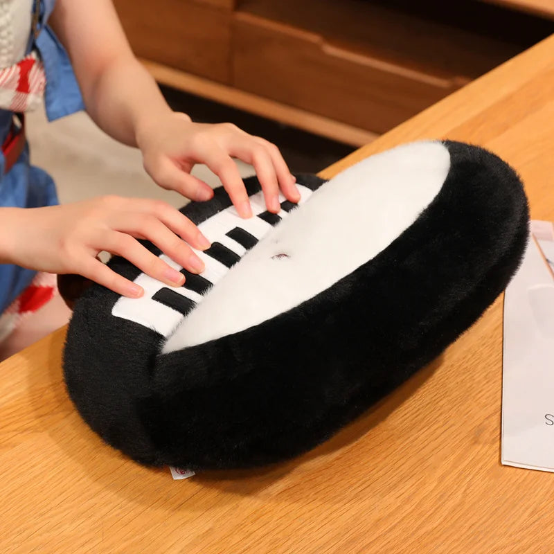 Anime music plush piano keychain pendant displayed next to a laptop on a study desk