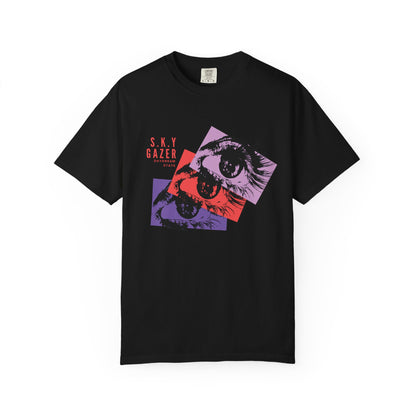 Artistic eye design tee on male model wearing washed black jeans in urban setting