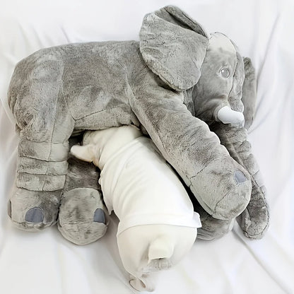 Baby elephant plush toy resting against a nursery pillow