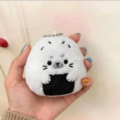 Baby seal plushie keychain attached to a pastel backpack zipper