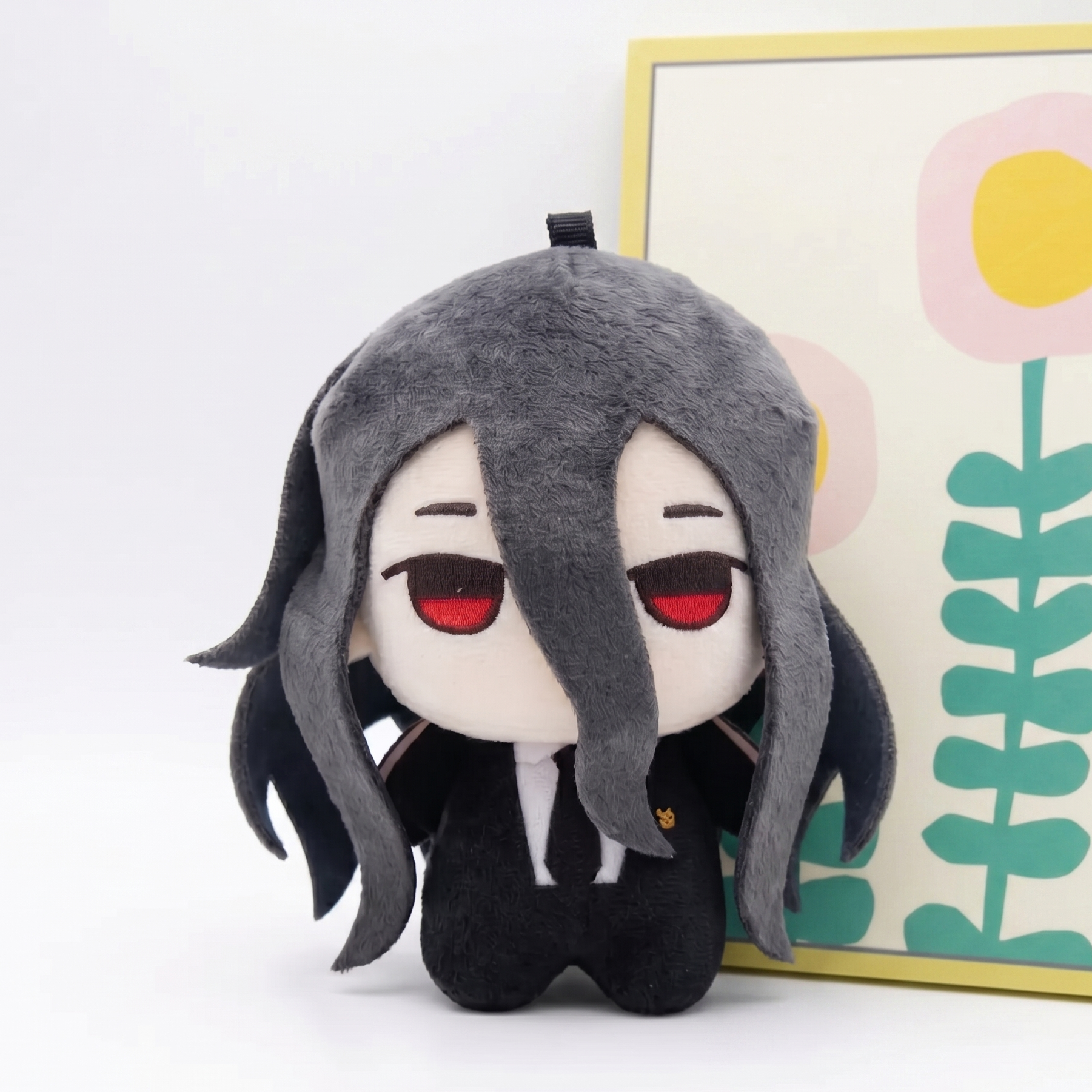 Close-up of Izuru plush black hair detail and red eye design
