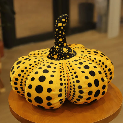 Close-up of pumpkin plushie showing soft plush texture and bold dot surface pattern
