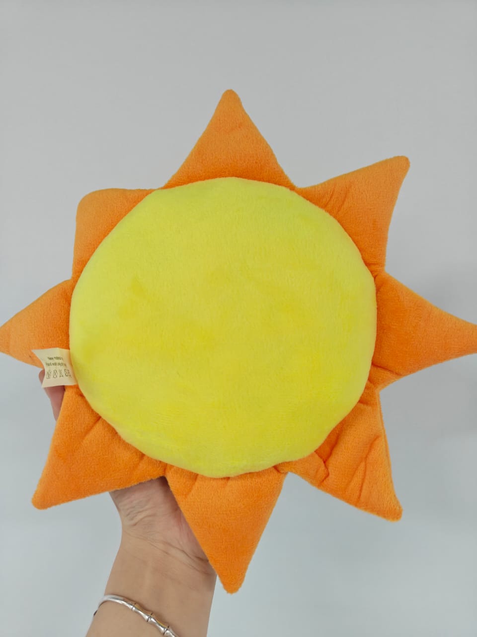 Close-up shot of the embroidered facial features and vibrant solar details on the Mr. Sun plush.
