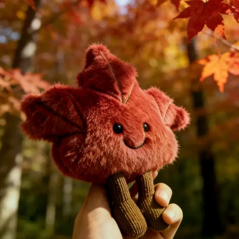 Close up of joyful smiling face detail on kawaii maple leaf plush toy