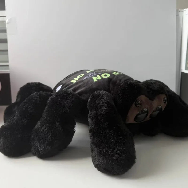 Close up of large glossy dome eyes on cute spider plush with clothing on