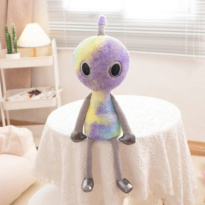 Cosmic stuffed animal kawaii alien in pink with dangling limbs flat lay