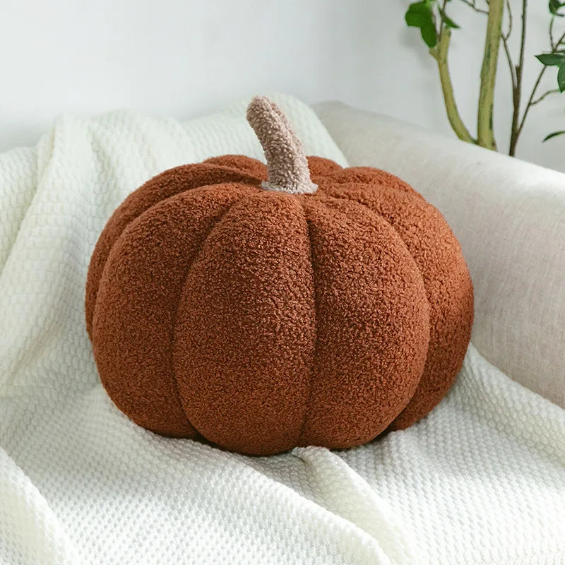 Cozy fall home decor flat lay featuring harvest pumpkin plush and foliage