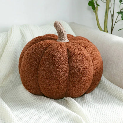 Cozy fall home decor flat lay featuring harvest pumpkin plush and foliage