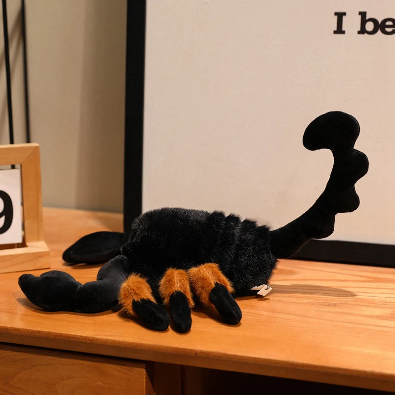 Creepy crawly plush scorpion toy placed on shelf among gothic décor and crystals
