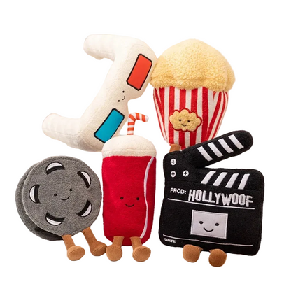 Cute cinema plush toys featuring smiling popcorn, cola can, 3D glasses, film reel and clapperboard characters on white background