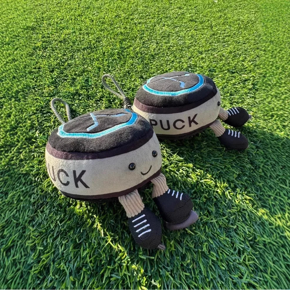Cute hockey plush puck stuffed toy wearing miniature ice skates close up detail