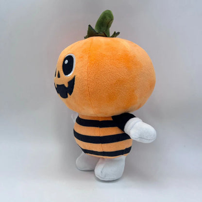 Cute pumpkin plushie sitting on autumn fall decor shelf