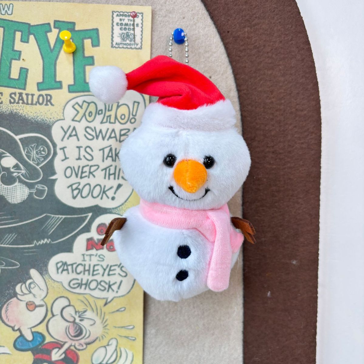 Cute snowman keychain plush bag charm attached to tote bag close-up