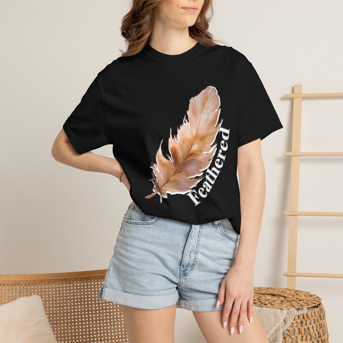 Feather graphic tee laid flat on wooden surface showcasing relaxed unisex fit