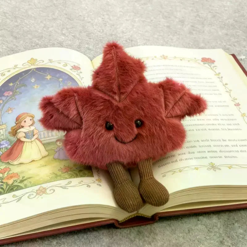 Front view of smiling maple leaf stuffed animal with soft fur body and corduroy legs
