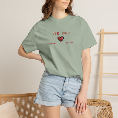Gamer gift tee flat lay with retro gaming inspired accessories showing pixel heart chest graphic detail
