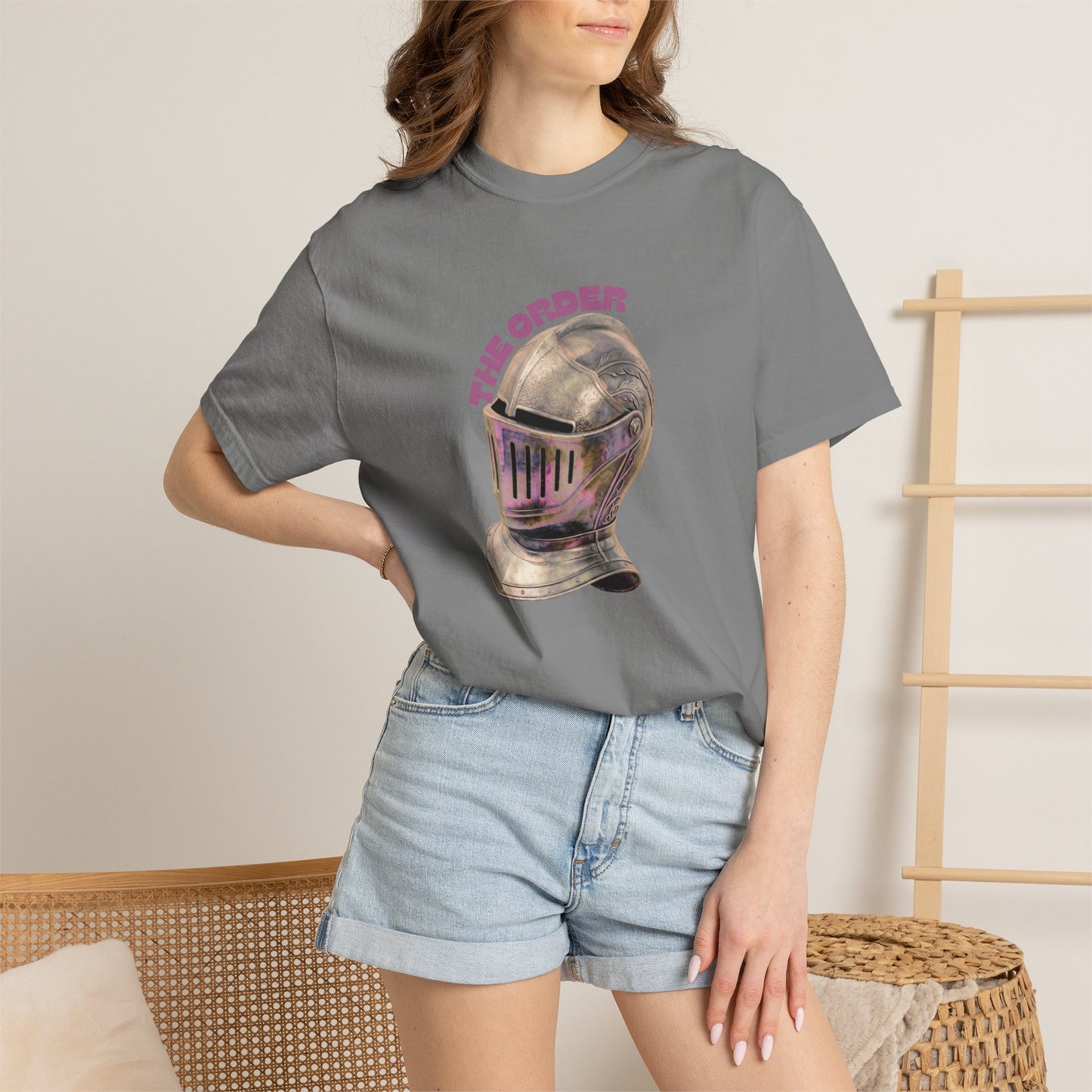 Gaming fan apparel knight crest tee flat lay on textured concrete surface
