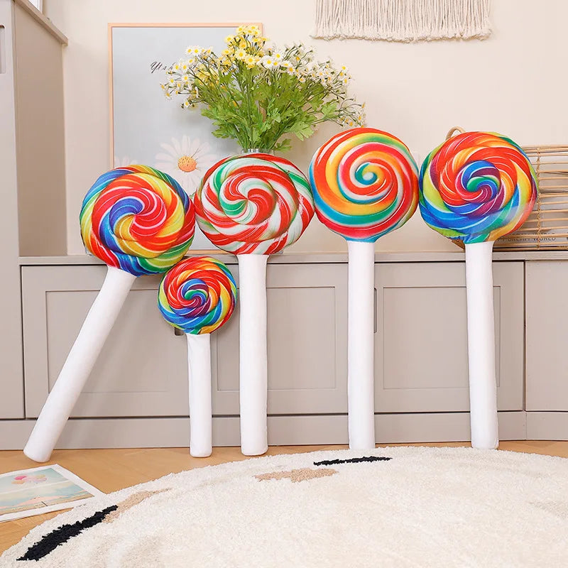 Giant candy plush cushion 70cm displayed upright on bedroom floor with pastel decor