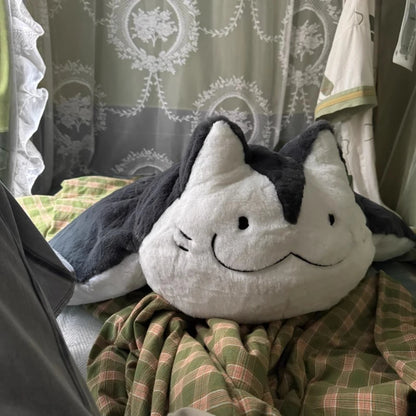 Giant manta ray stuffed animal displayed as decorative cushion on grey sofa