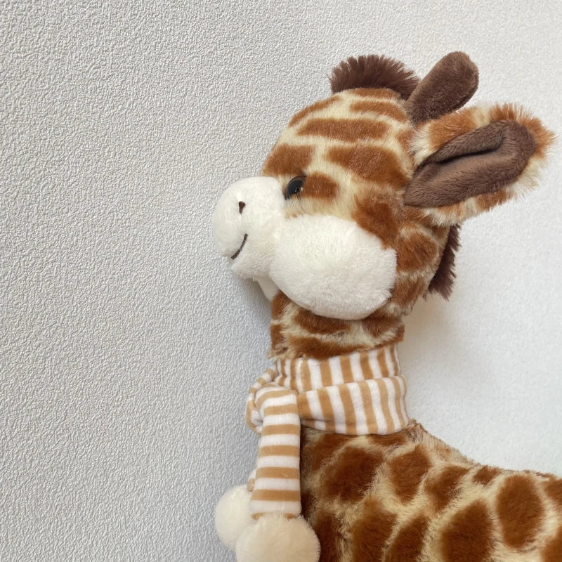 Giraffe plushie sitting upright showing nursery decor styling on a wooden shelf