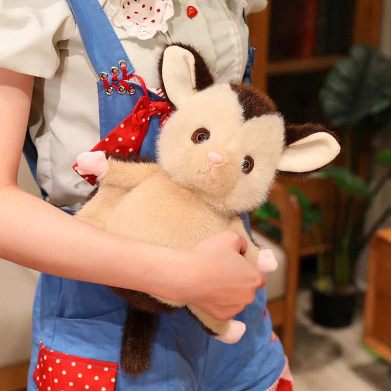 Glider plush side profile showing patagium-inspired wing detail on fabric
