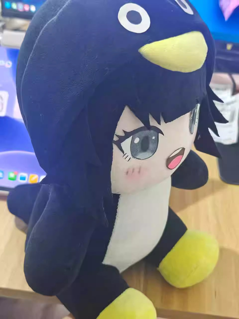 Gugu Gaga Penguin plush placed on gaming desk beside keyboard
