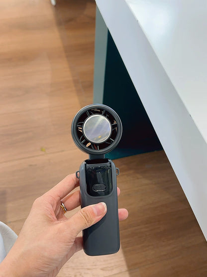 Handheld fan head tilted 90 degrees showing full tilt range adjustment
