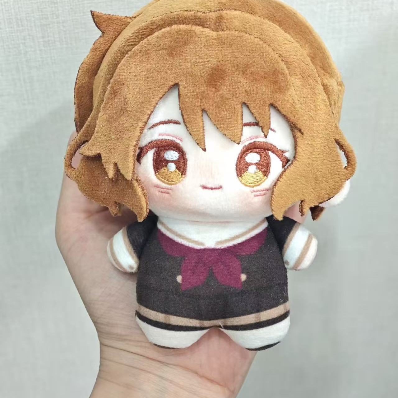 Handmade anime plush toy displayed on a desk shelf beside other collectibles