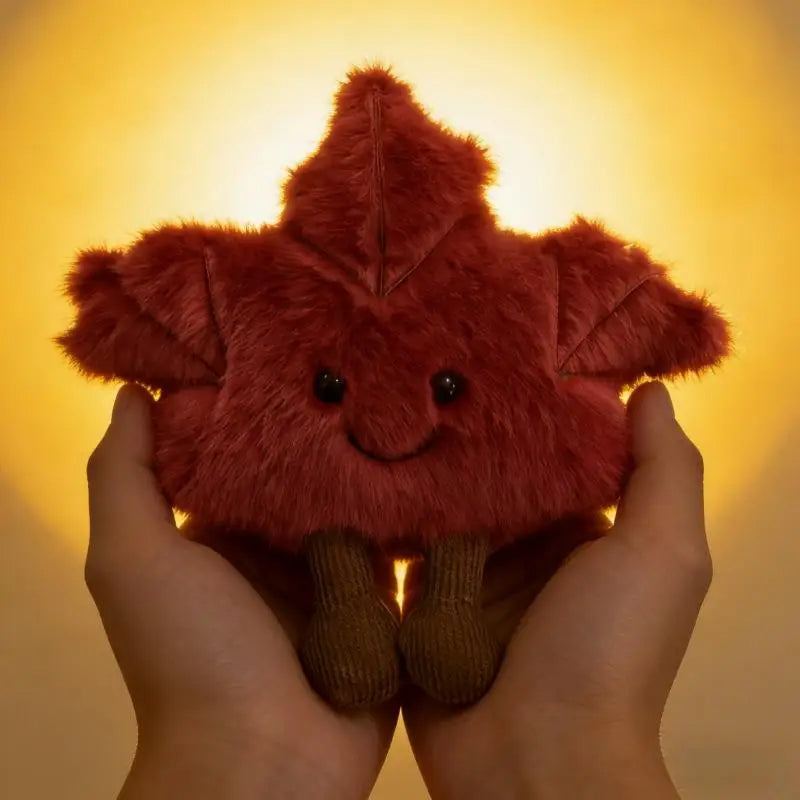 Handmade autumn plush toy in warm red and orange maple leaf silhouette