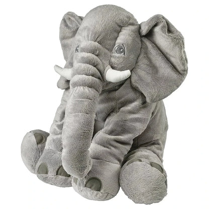 Handmade elephant plushie sitting on a pastel nursery shelf