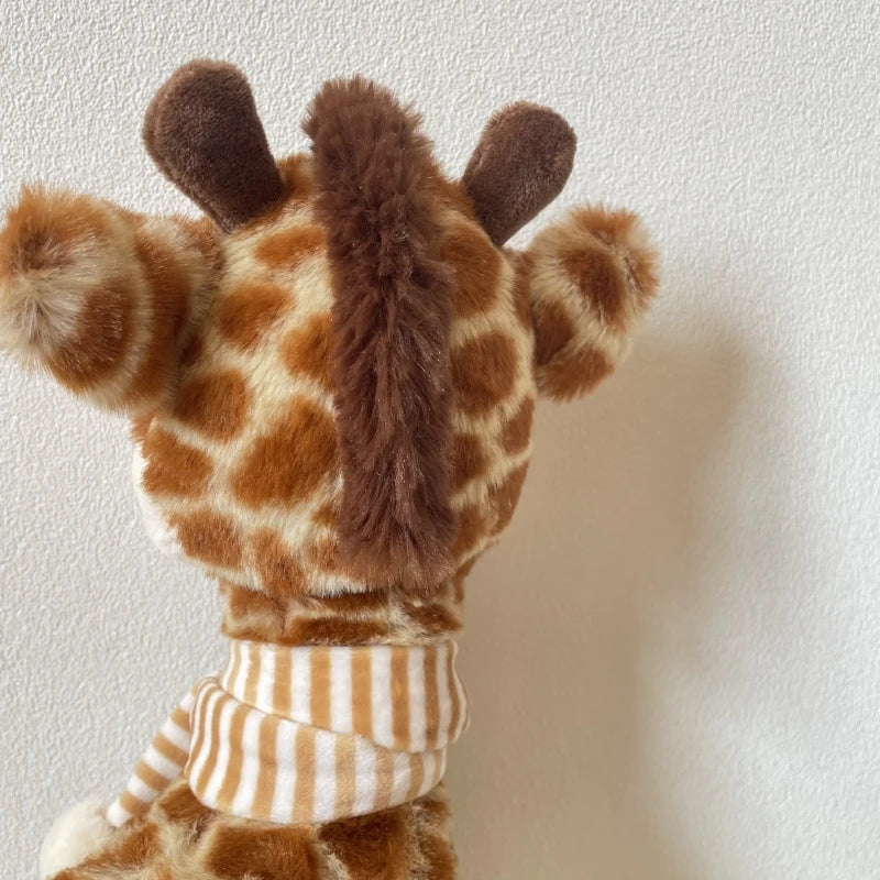 Handmade giraffe stuffed animal 32cm size comparison next to a baby's hand