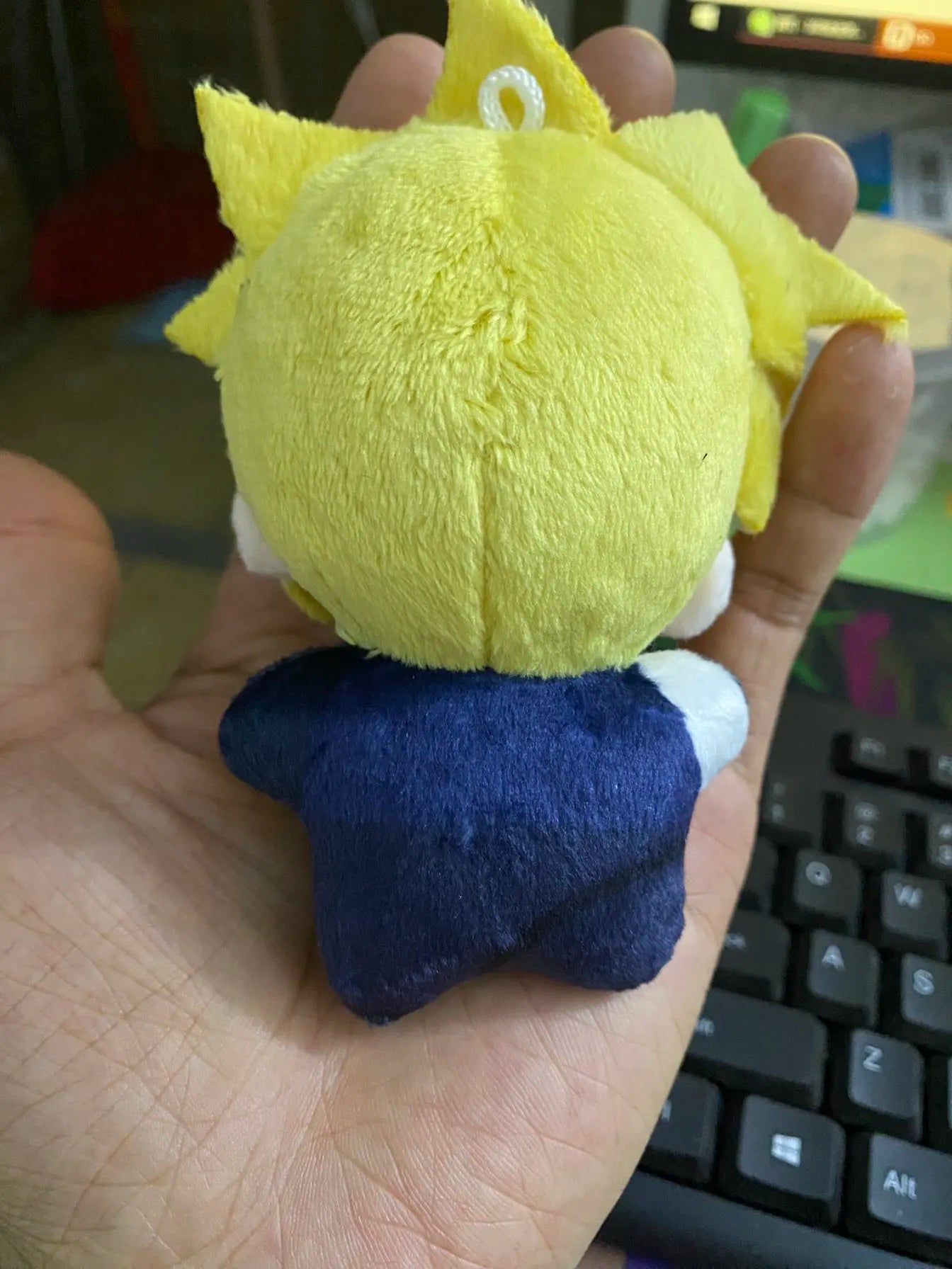 Handmade strife plush standing next to common object for size reference
