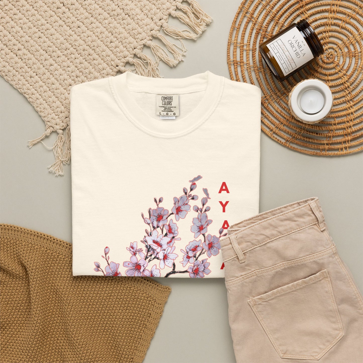 Illustrated graphic tee with yokai mask, vertical AYAKASHI lettering, and floral detail