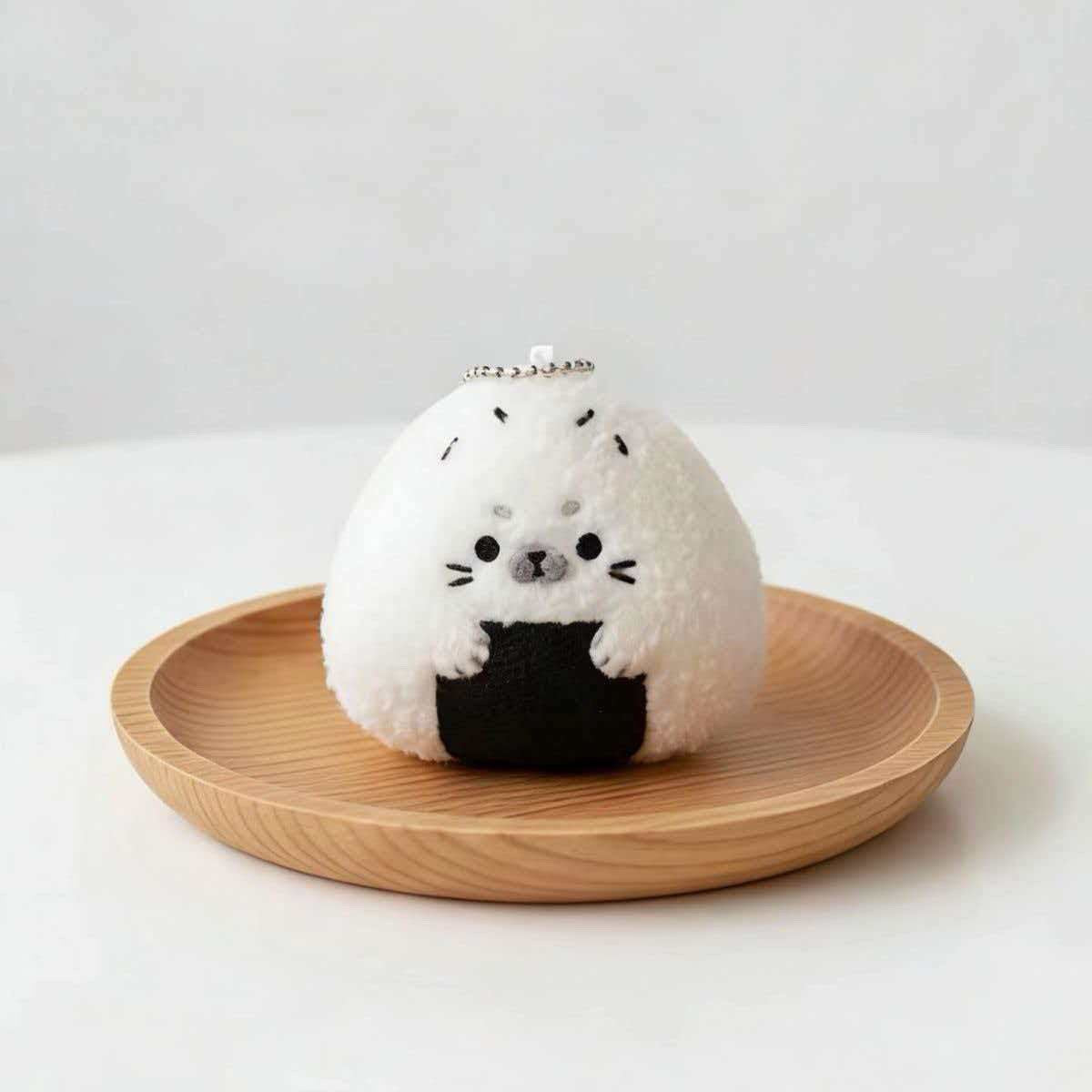 Kawaii baby seal plushie shaped like a Japanese rice ball, front view