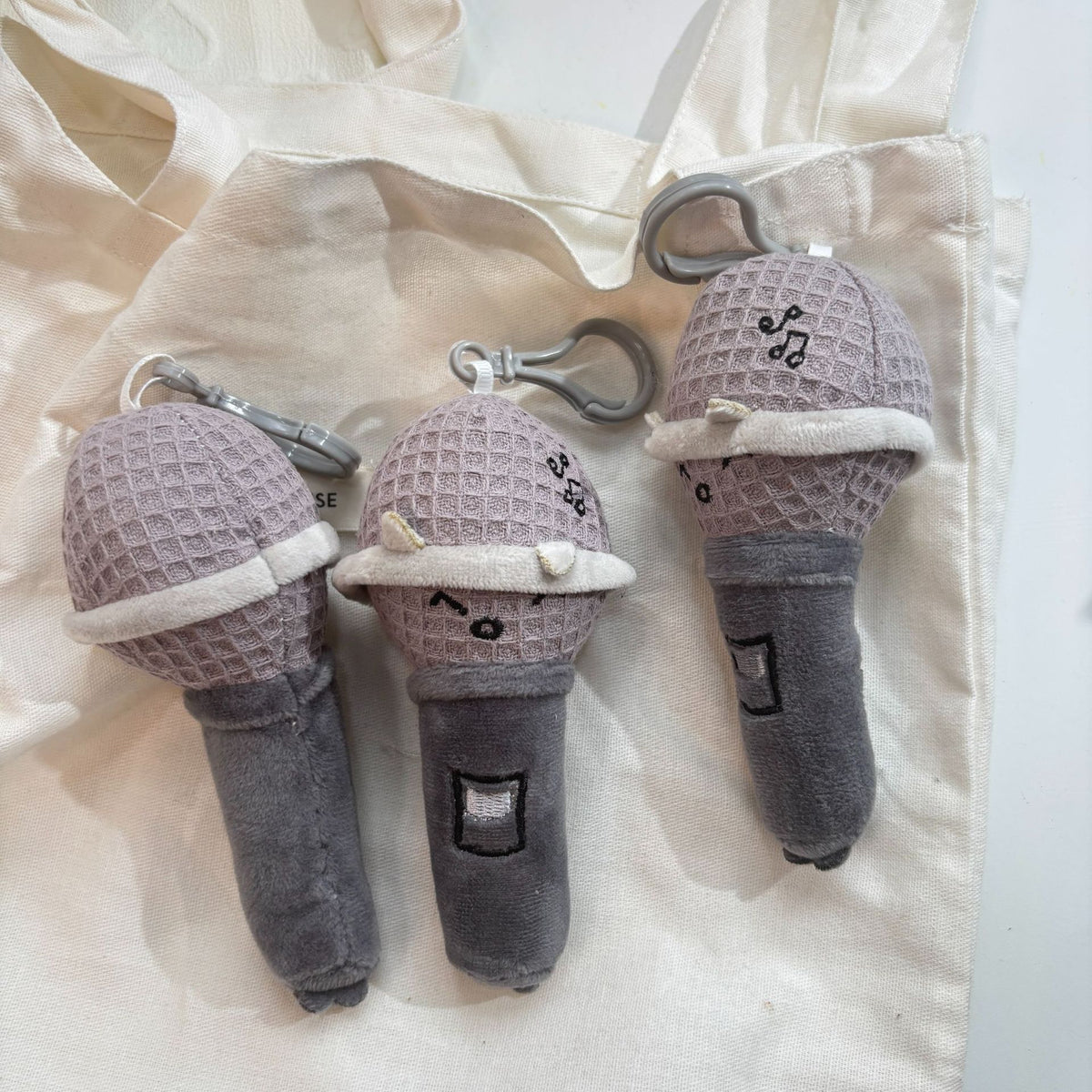 Kawaii mic plush flat lay next to headphones and music accessories