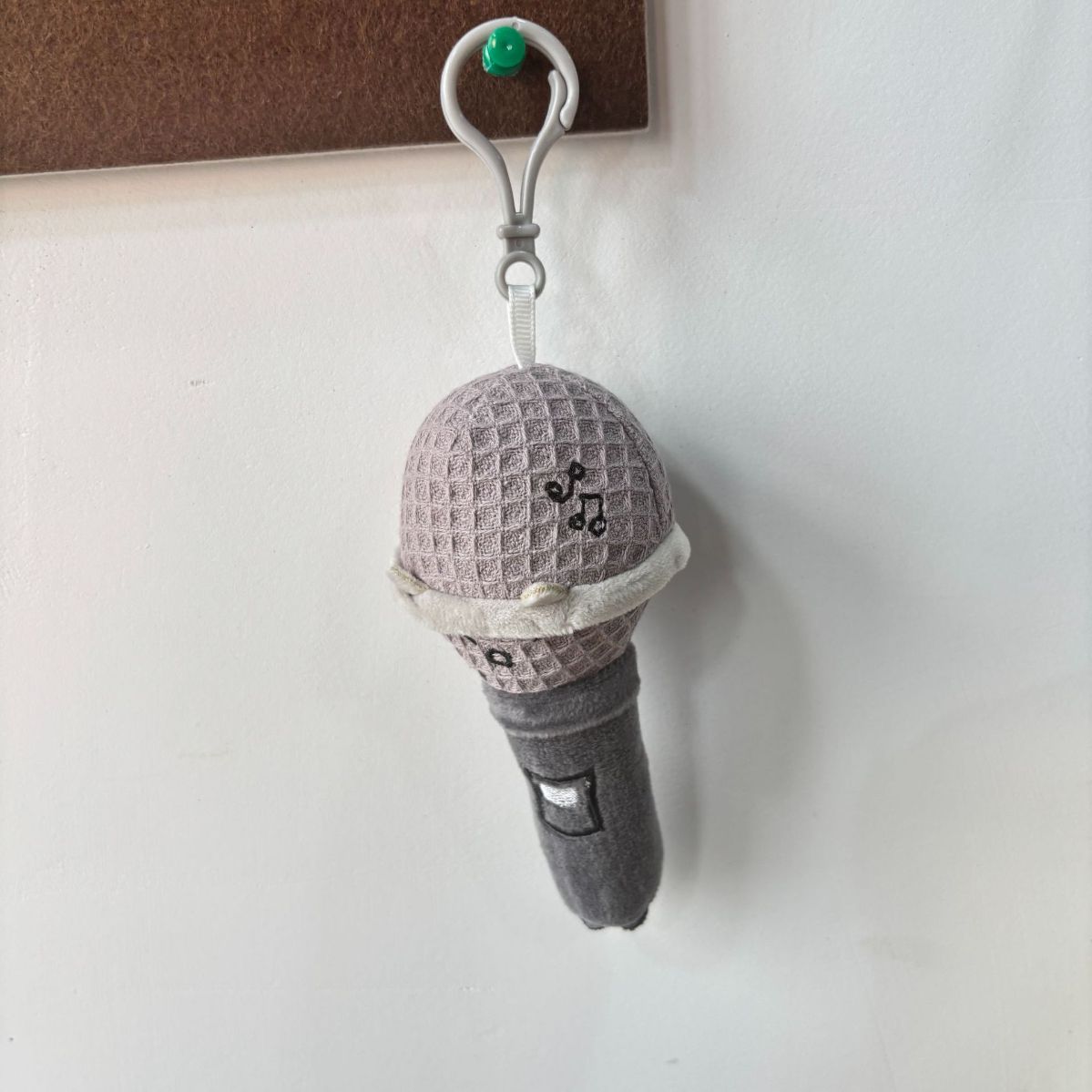Kawaii microphone plushie keychain front view with cartoon face expression