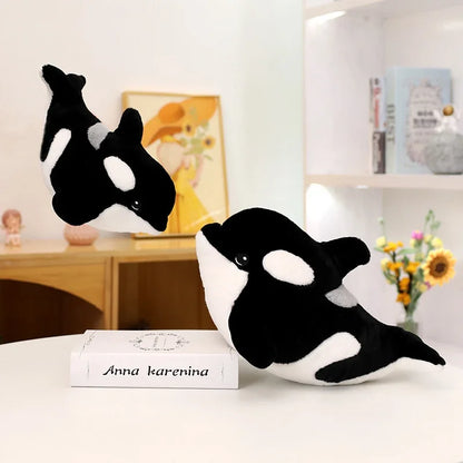 Killer whale plush toy held by hand to show scale comparison