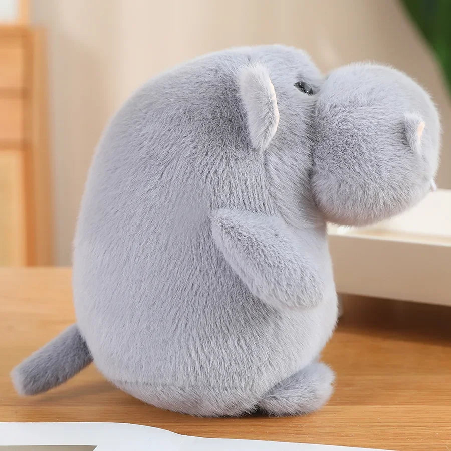 Large chonky hippo plushie propped against bedroom pillow as room decor