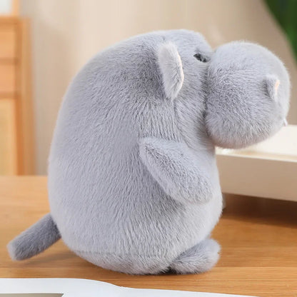 Large chonky hippo plushie propped against bedroom pillow as room decor