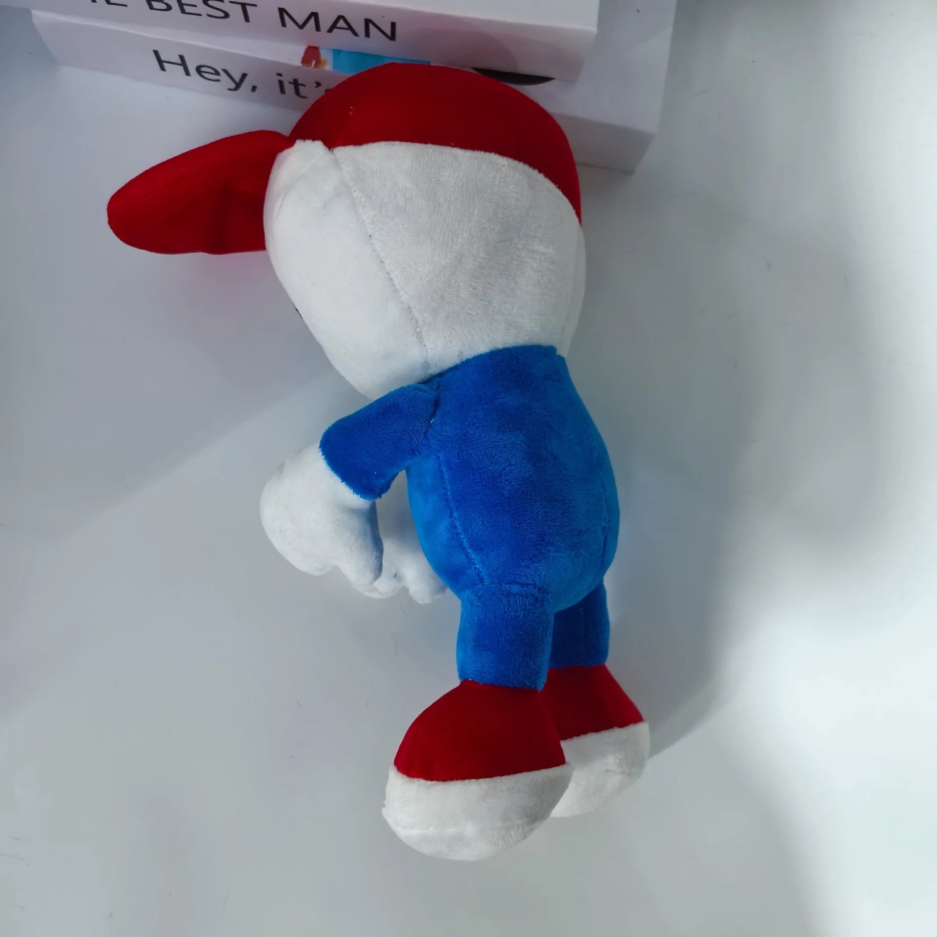 Mellow stuffed toy pale skinned limbless character with red cap