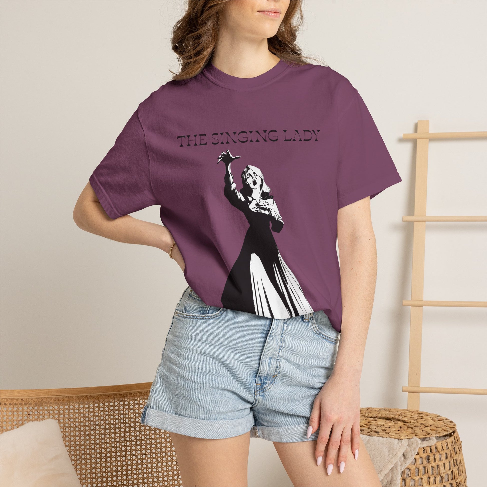 Monochrome graphic tee photographed in natural light on plain backdrop
