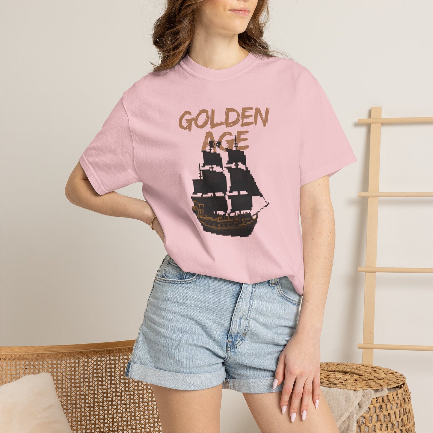 Ocean adventure tee flat lay on a sandy beach with driftwood props

