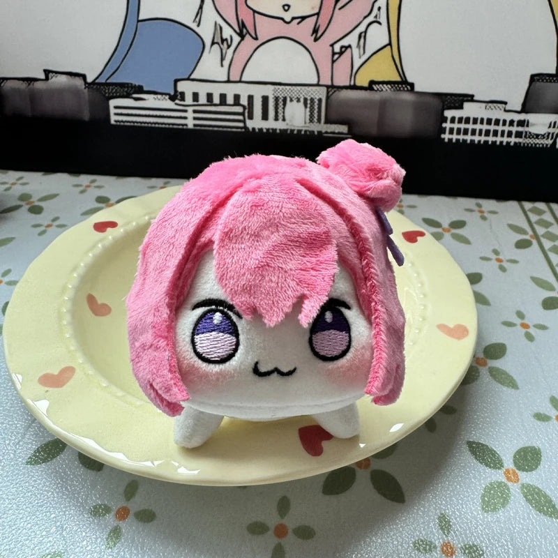 Pink Doro plush keychain clipped to a black backpack zipper