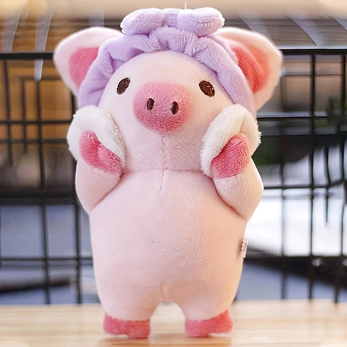 Pink pig plushie keychain attached to bag strap lifestyle shot